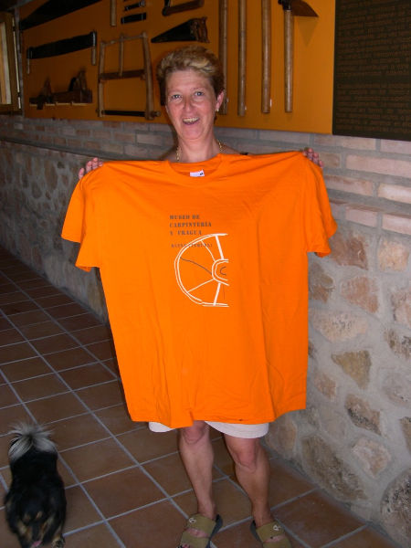 Miguela Sanz enseñándonos una camiseta del museo de la carpintería y fragua